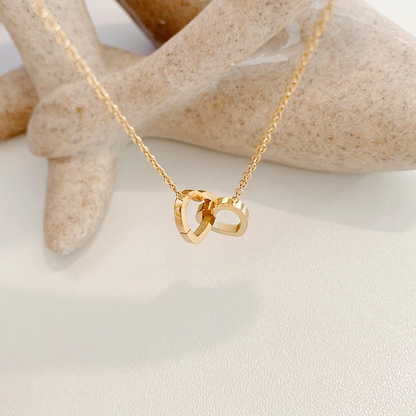 Elegant gold heart necklace displayed on a jewelry stand  
