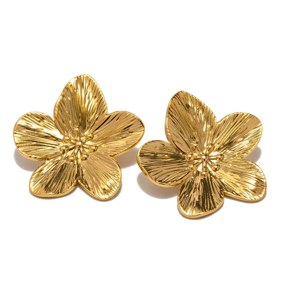 Luxurious gold flower earrings displayed on a soft jewelry pouch.